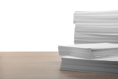 Photo of Stacks of paper sheets on wooden table against white background. Space for text