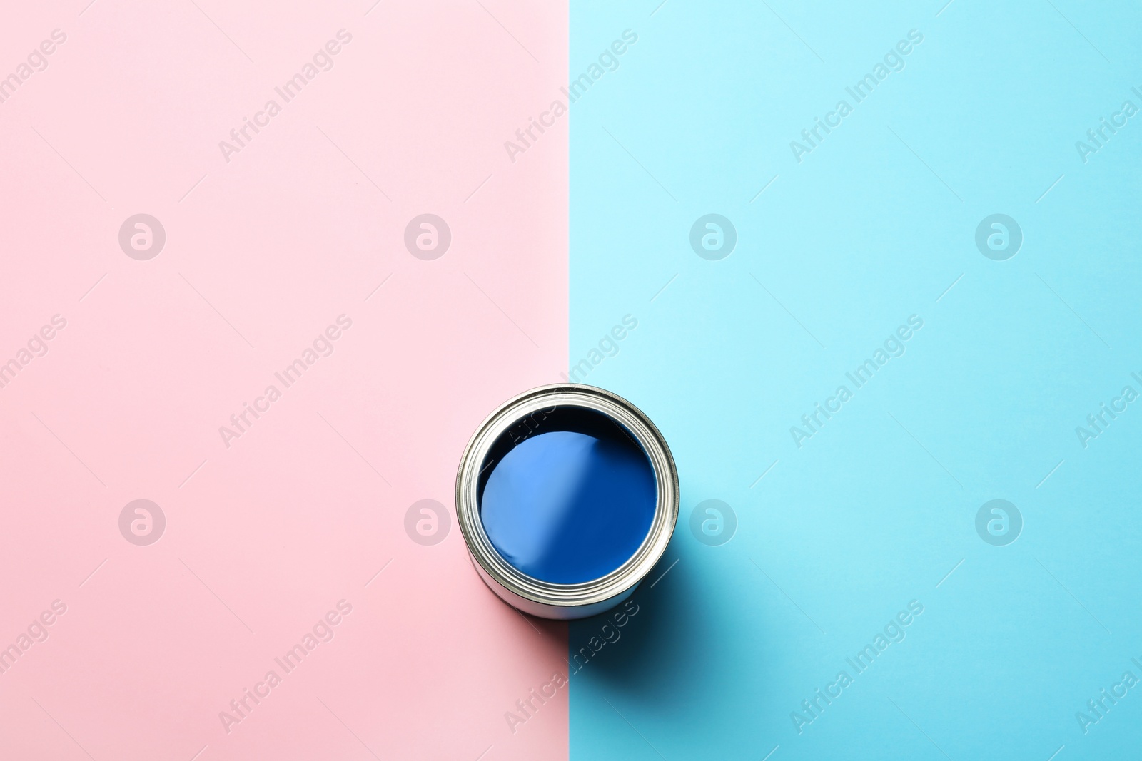 Photo of Open paint can and space for text on color background, top view