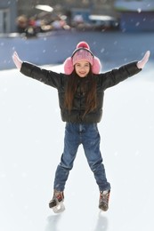 Image of Cute little girl at outdoor ice skating rink