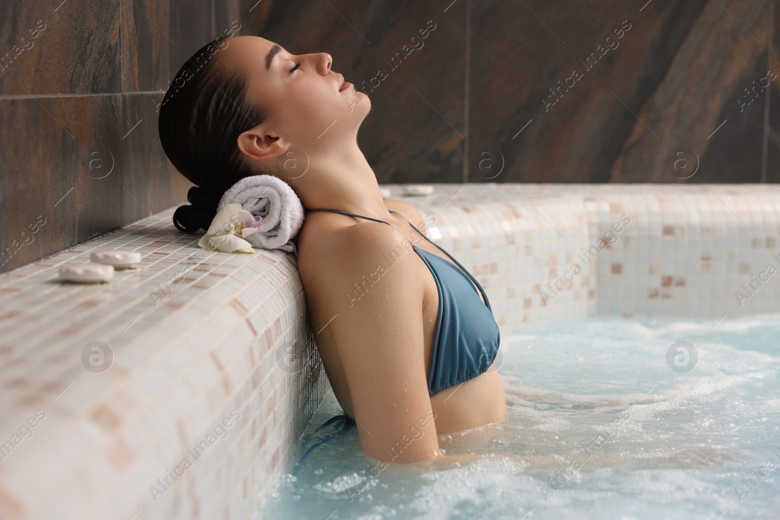 Photo of Beautiful woman with orchid flower relaxing in spa swimming pool