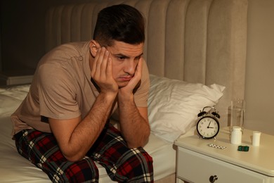 Photo of Man suffering from insomnia on bed at night