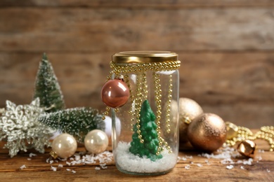 Handmade snow globe and Christmas decorations on wooden table