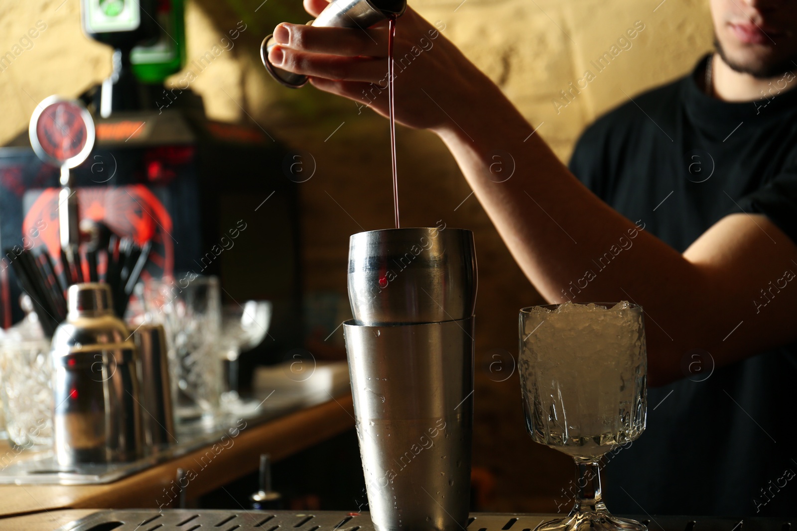 Photo of Bartender preparing fresh alcoholic cocktail at bar counter, closeup