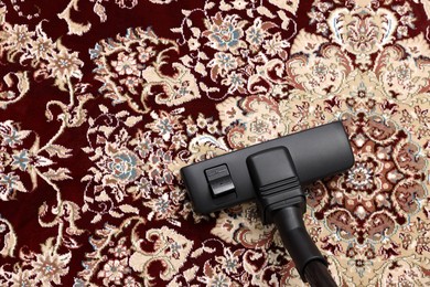 Photo of Hoovering carpet with vacuum cleaner, above view. Space for text