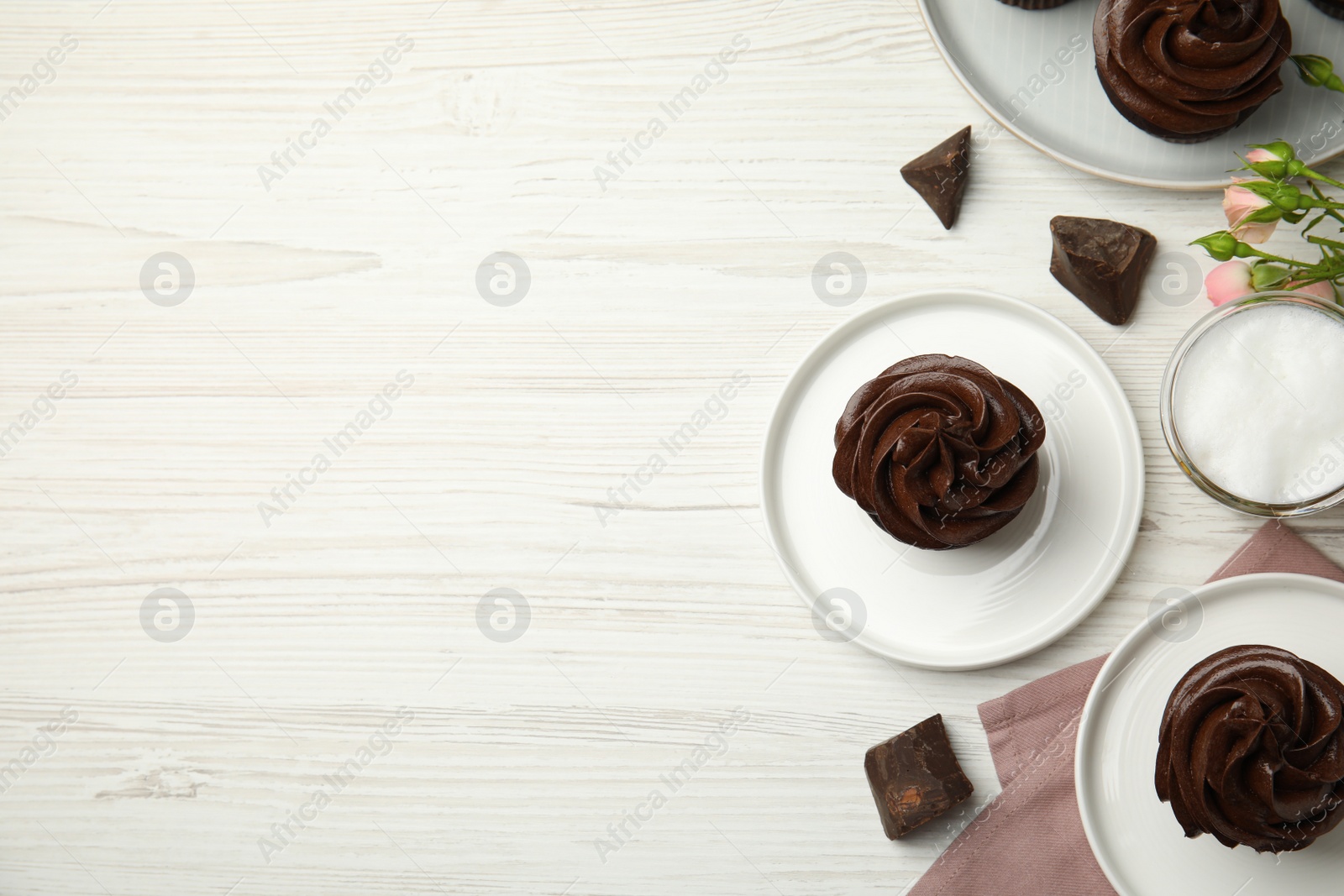 Photo of Flat lay composition with delicious chocolate cupcakes on white wooden table. Space for text
