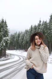 Young woman near snowy forest. Winter vacation