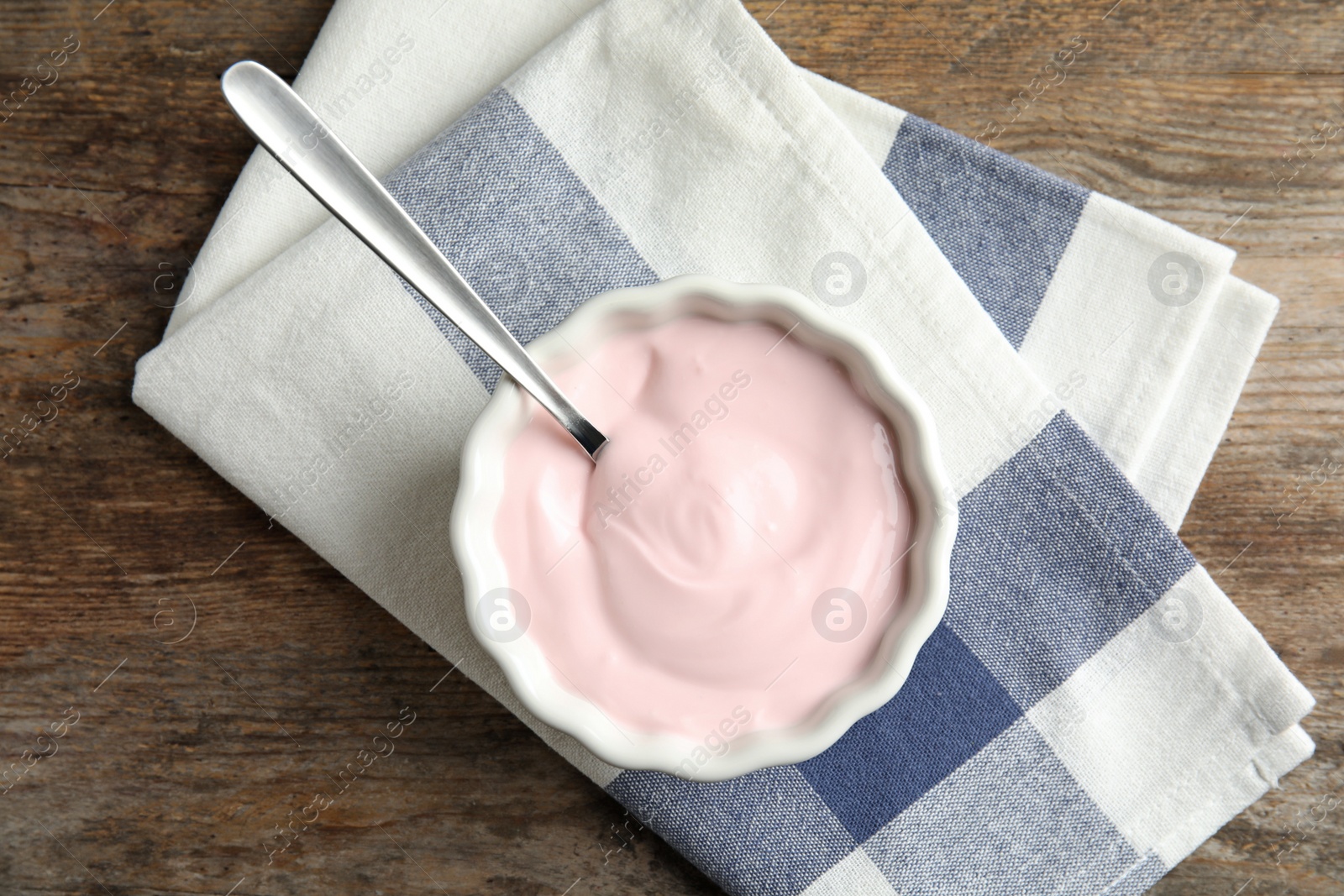 Photo of Bowl with creamy yogurt served on table, top view