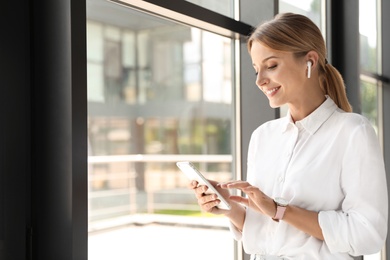 Photo of Portrait of female business trainer with smartphone indoors