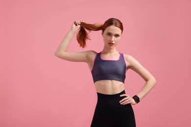 Young woman in sportswear on pink background, space for text