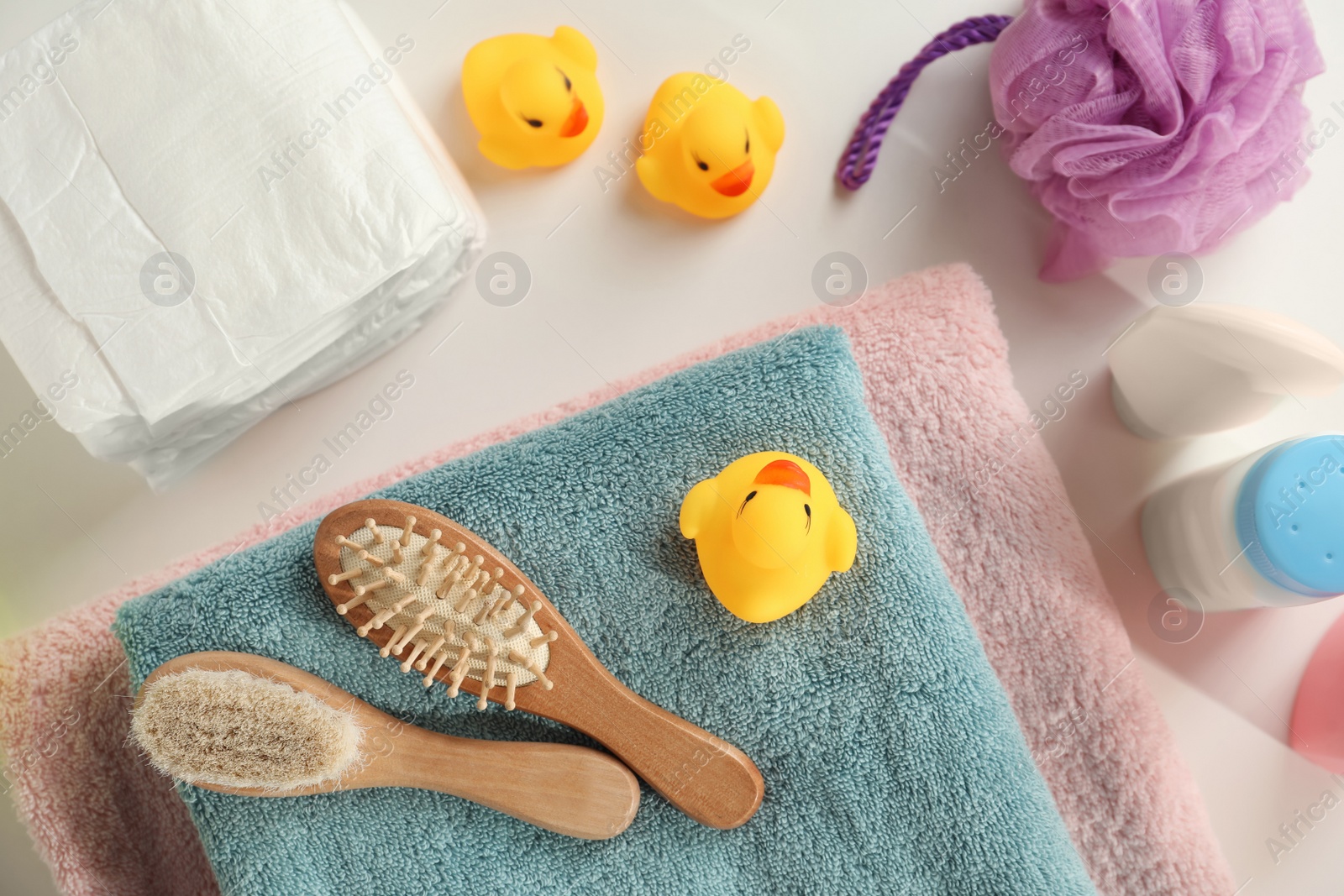 Photo of Towels, rubber ducks, hygrometer and baby care products on white table, flat lay