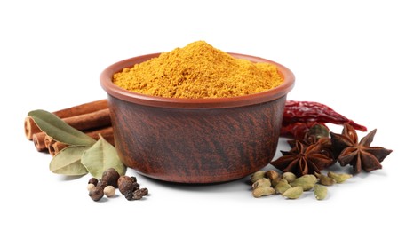 Curry powder in bowl and other spices isolated on white