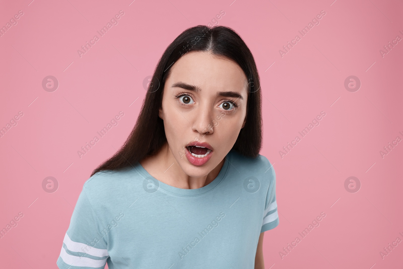 Photo of Portrait of surprised woman on pink background