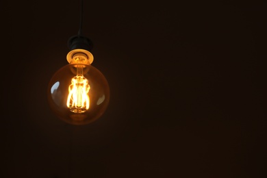 Lamp bulb on dark background. Space for text