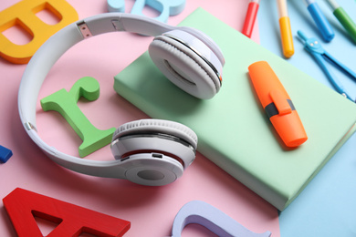 Photo of Book, headphones and stationery on color background