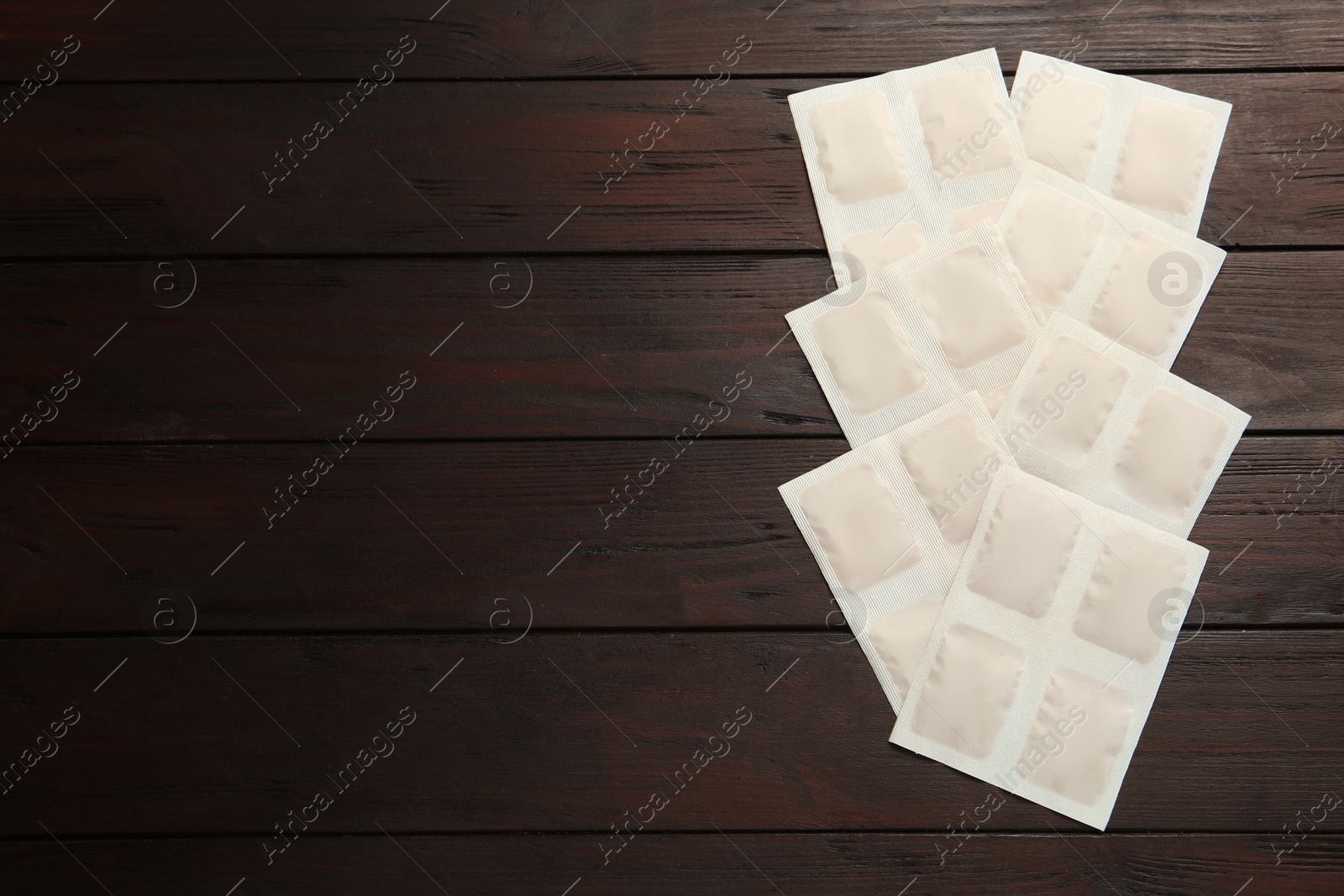 Photo of Mustard plasters on wooden table, flat lay. Space for text