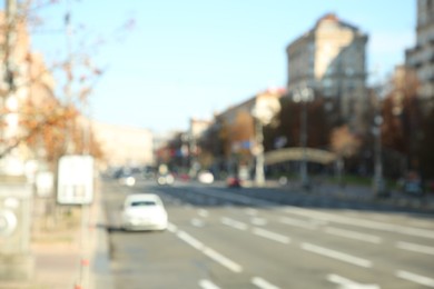 Photo of Blurred view of quiet city street with buildings and cars on road