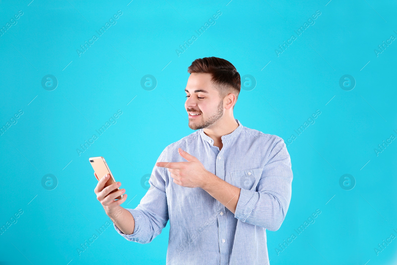 Photo of Man using mobile phone for video chat on color background