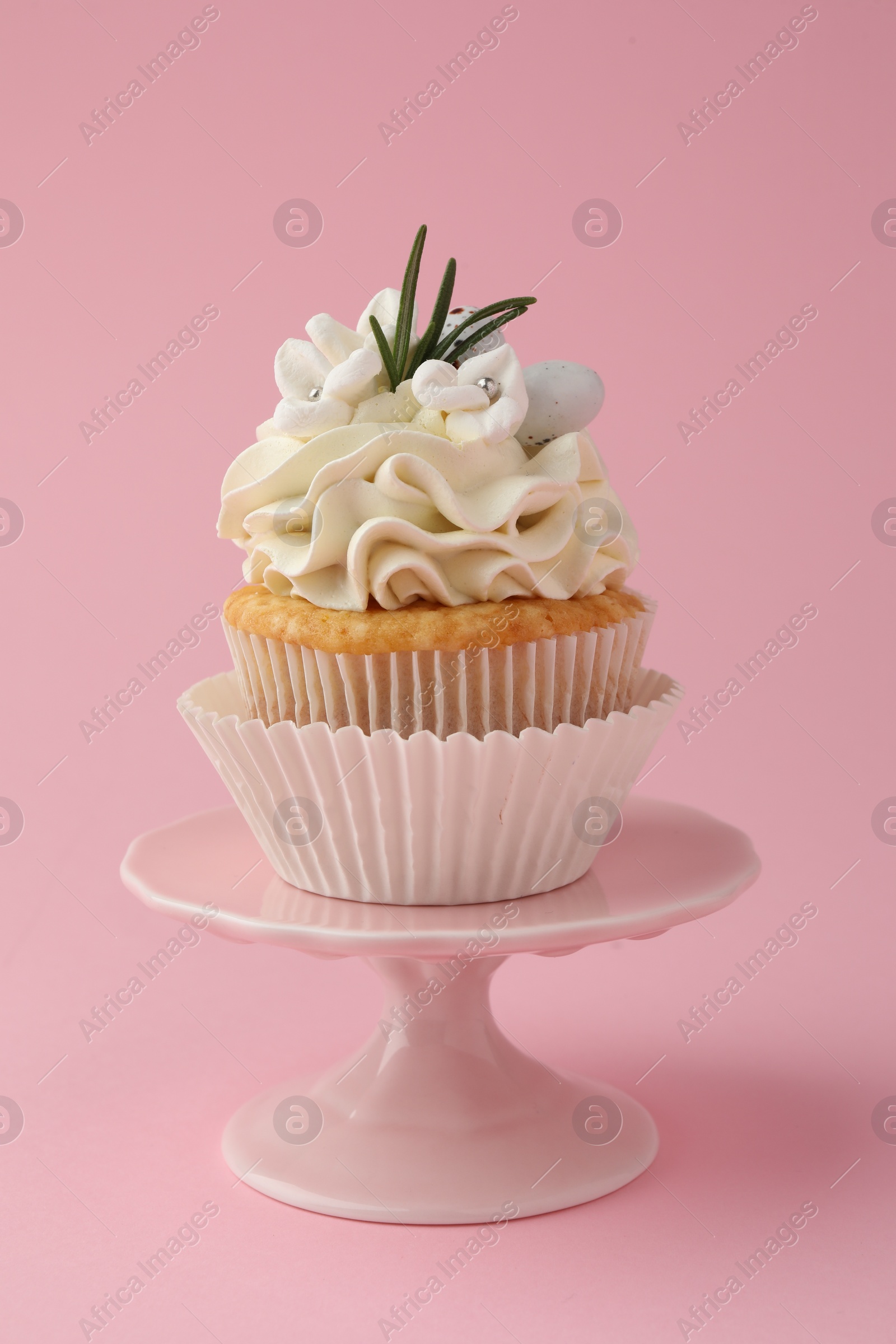 Photo of Tasty Easter cupcake with vanilla cream on pink background