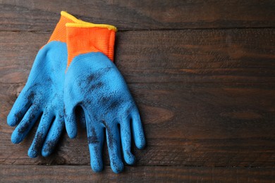 Photo of Pair of color gardening gloves on wooden table, top view. Space for text