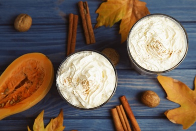 Photo of Flat lay composition with tasty pumpkin spice latte on wooden table