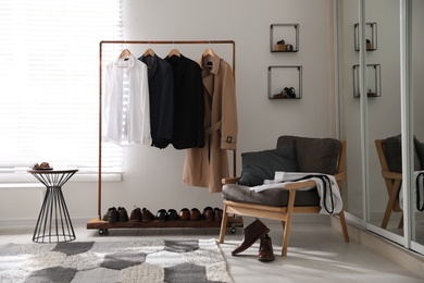 Photo of Dressing room interior with clothing rack and armchair