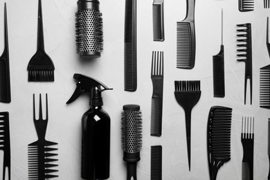 Photo of Flat lay composition with hair brushes and combs on light  grey stone background
