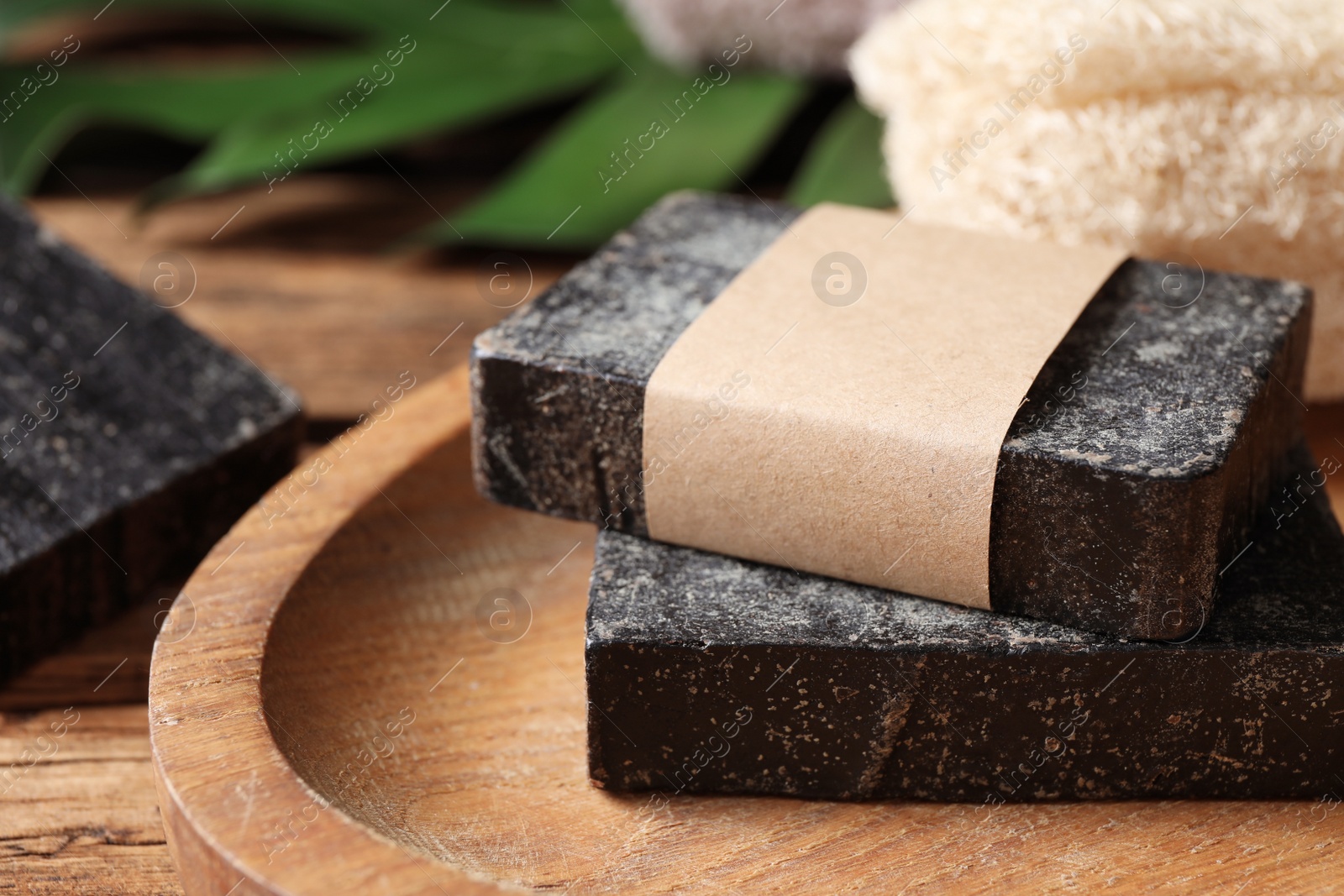 Photo of Natural tar soap on wooden table, closeup