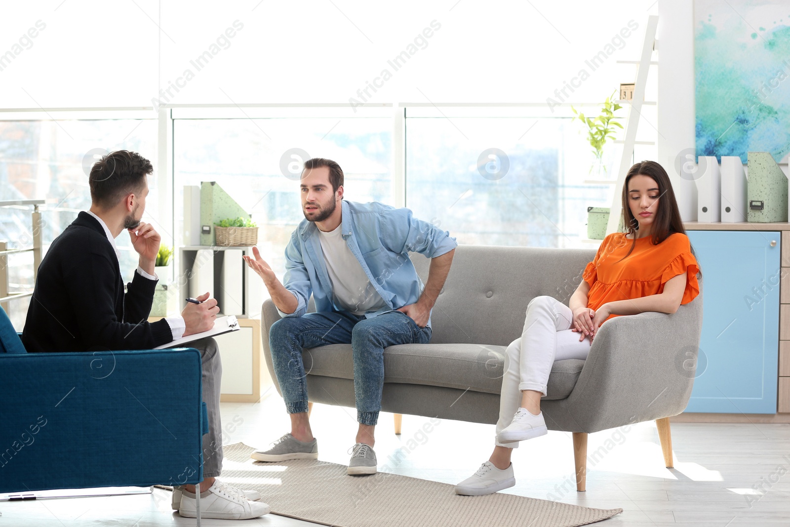 Photo of Family psychologist working with young couple in office