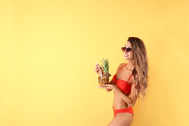 Photo of Pretty sexy woman in stylish bikini with cocktail on color background, space for text