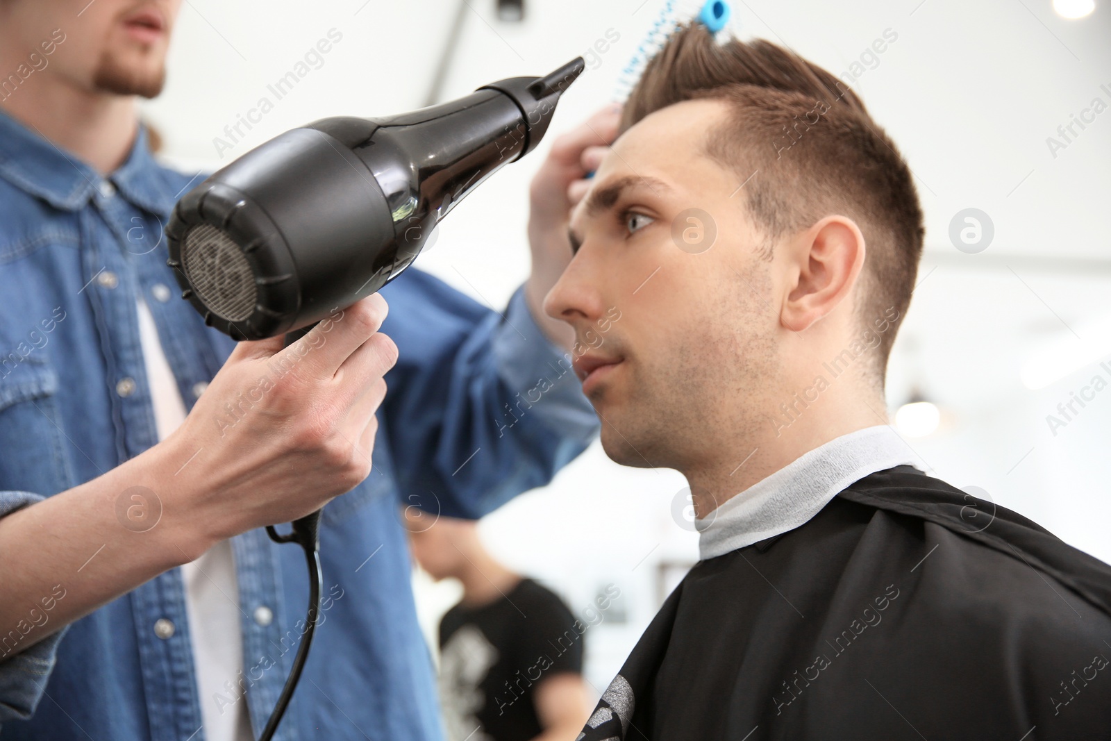 Photo of Professional barber working with client in hairdressing salon. Hipster fashion