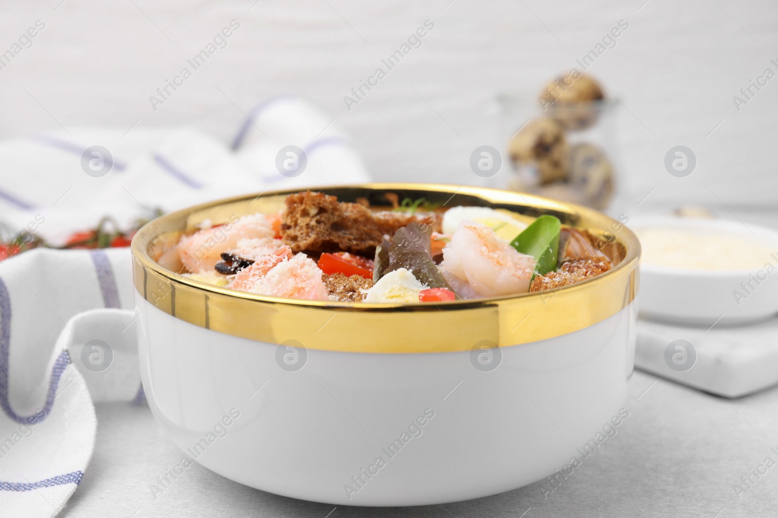 Photo of Delicious salad with croutons, tomatoes and shrimp served on white table, closeup