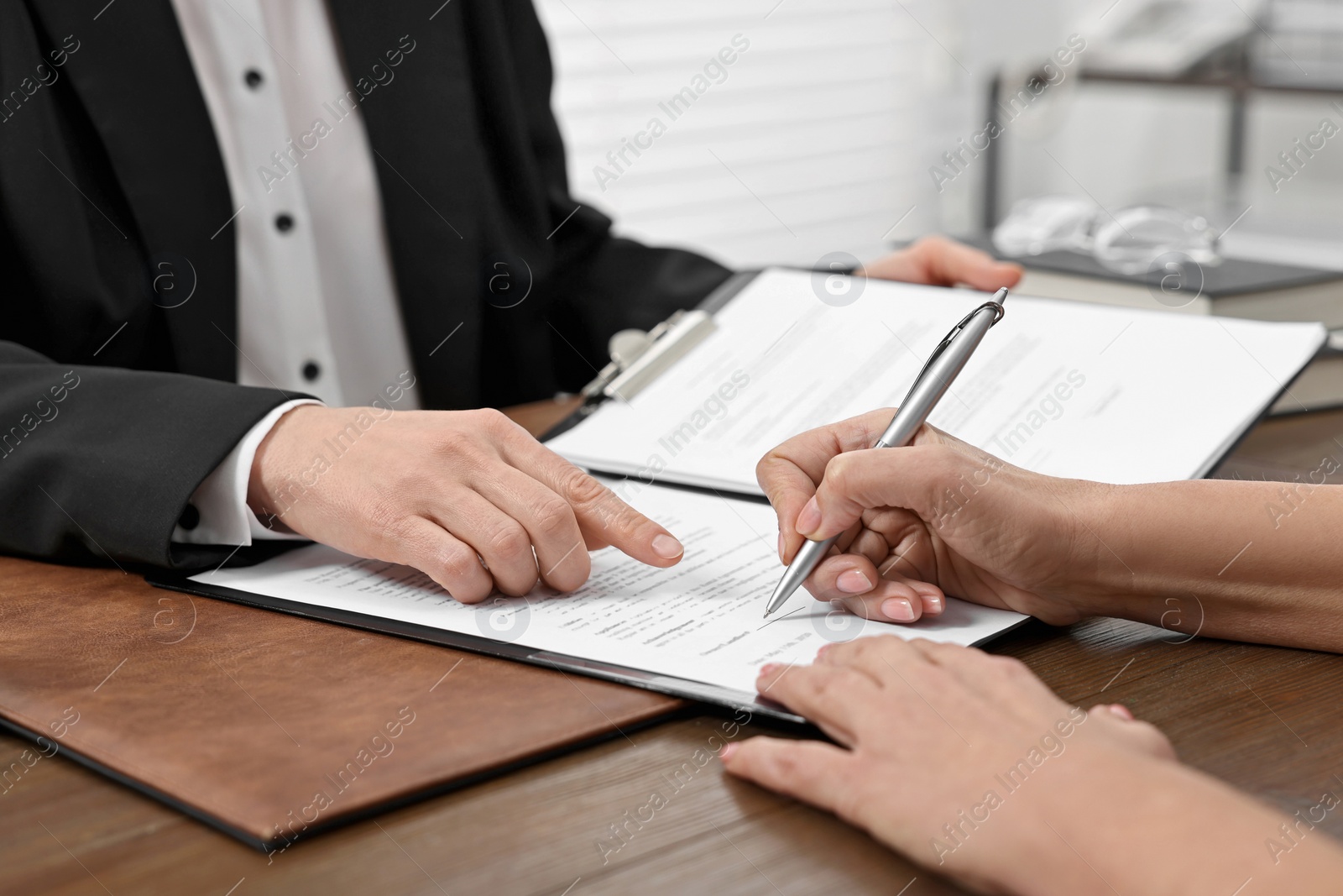 Photo of Senior woman signing document in lawyer's office, closeup