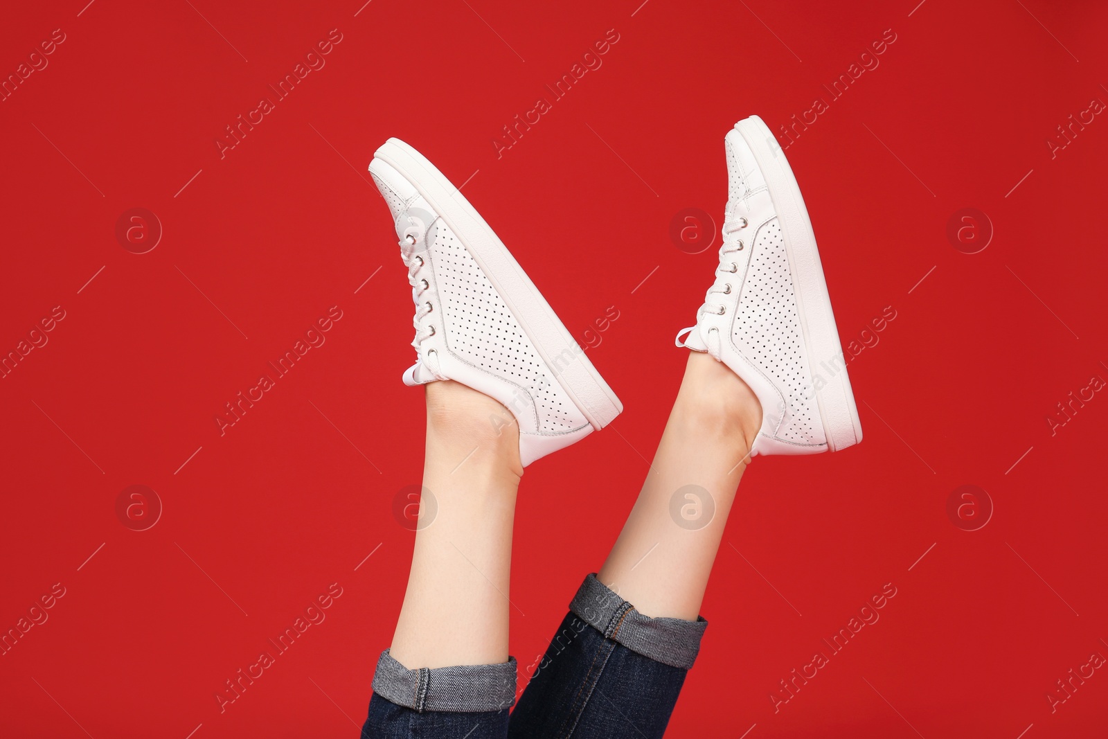 Photo of Woman in stylish sport shoes on color background