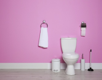 Photo of New ceramic toilet bowl in modern bathroom with space for text