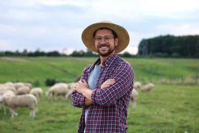 Photo of Portrait of smiling man with crossed arms on pasture at farm