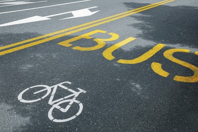 Photo of Bicycle and bus lane signs painted on asphalt