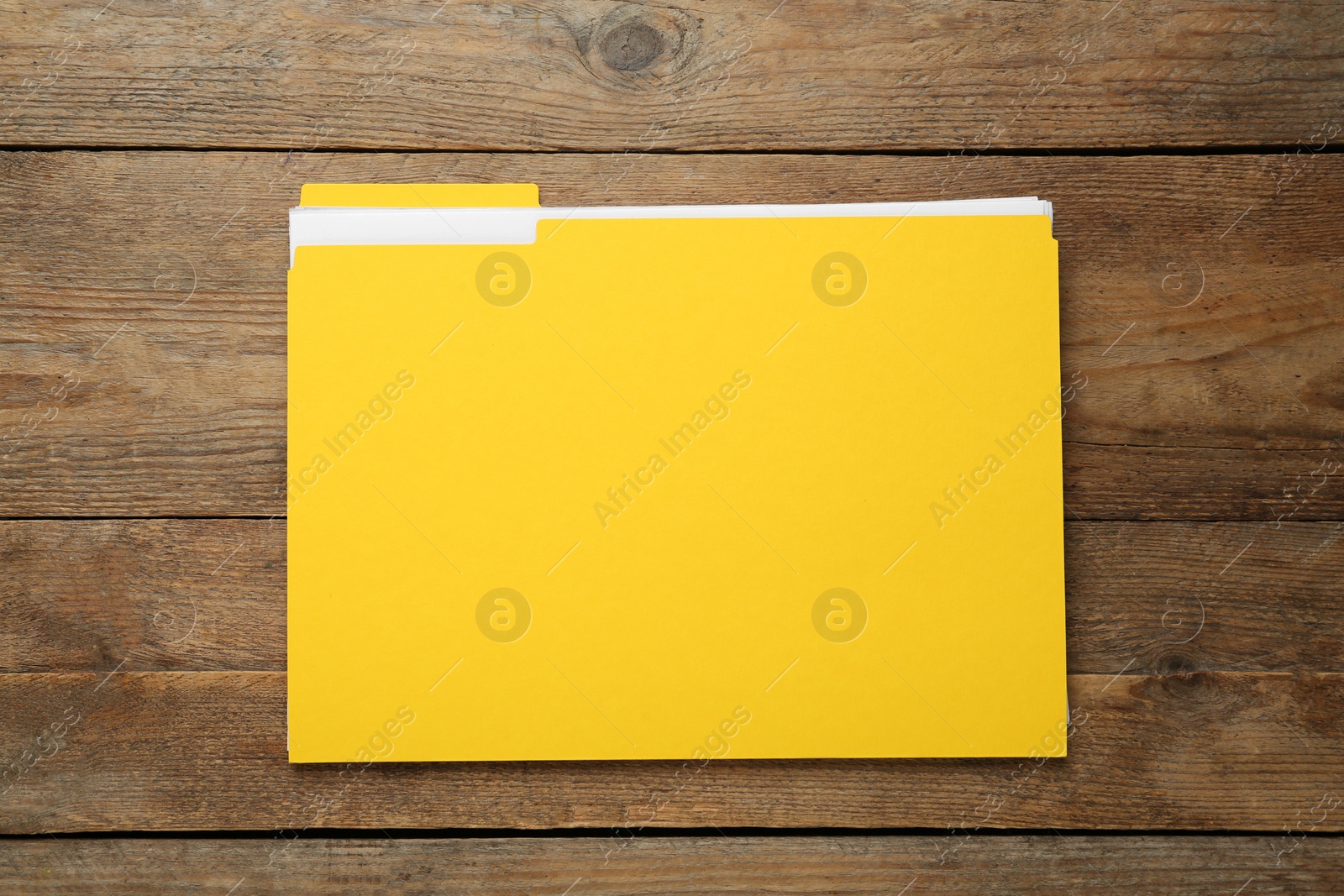 Photo of Yellow file with documents on wooden table, top view