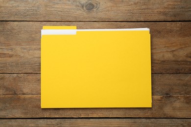 Yellow file with documents on wooden table, top view