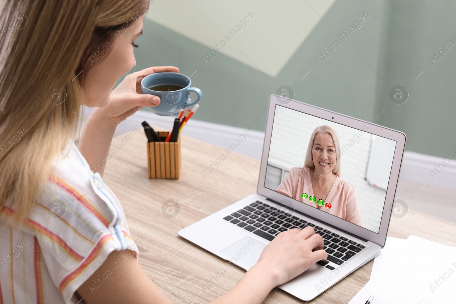Image of Young woman having video chat with her grandmother at home