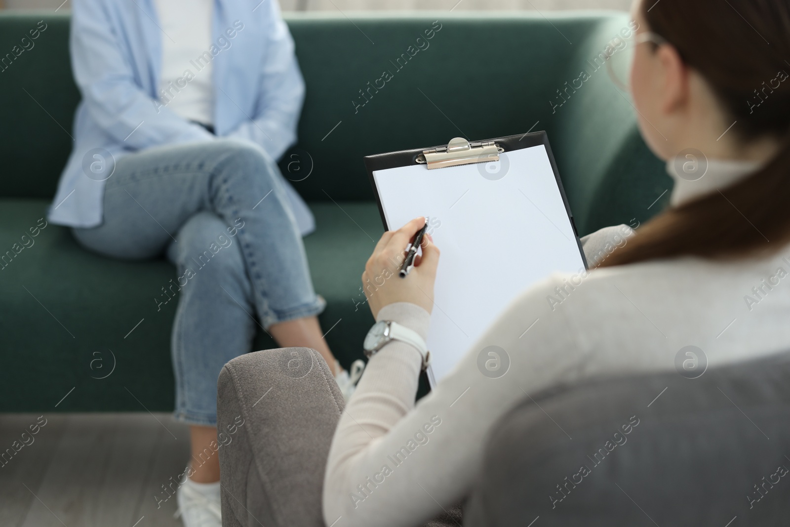 Photo of Professional psychotherapist working with patient in office, closeup