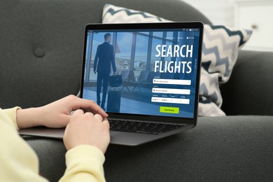 Image of Woman using laptop to book flight at home, closeup