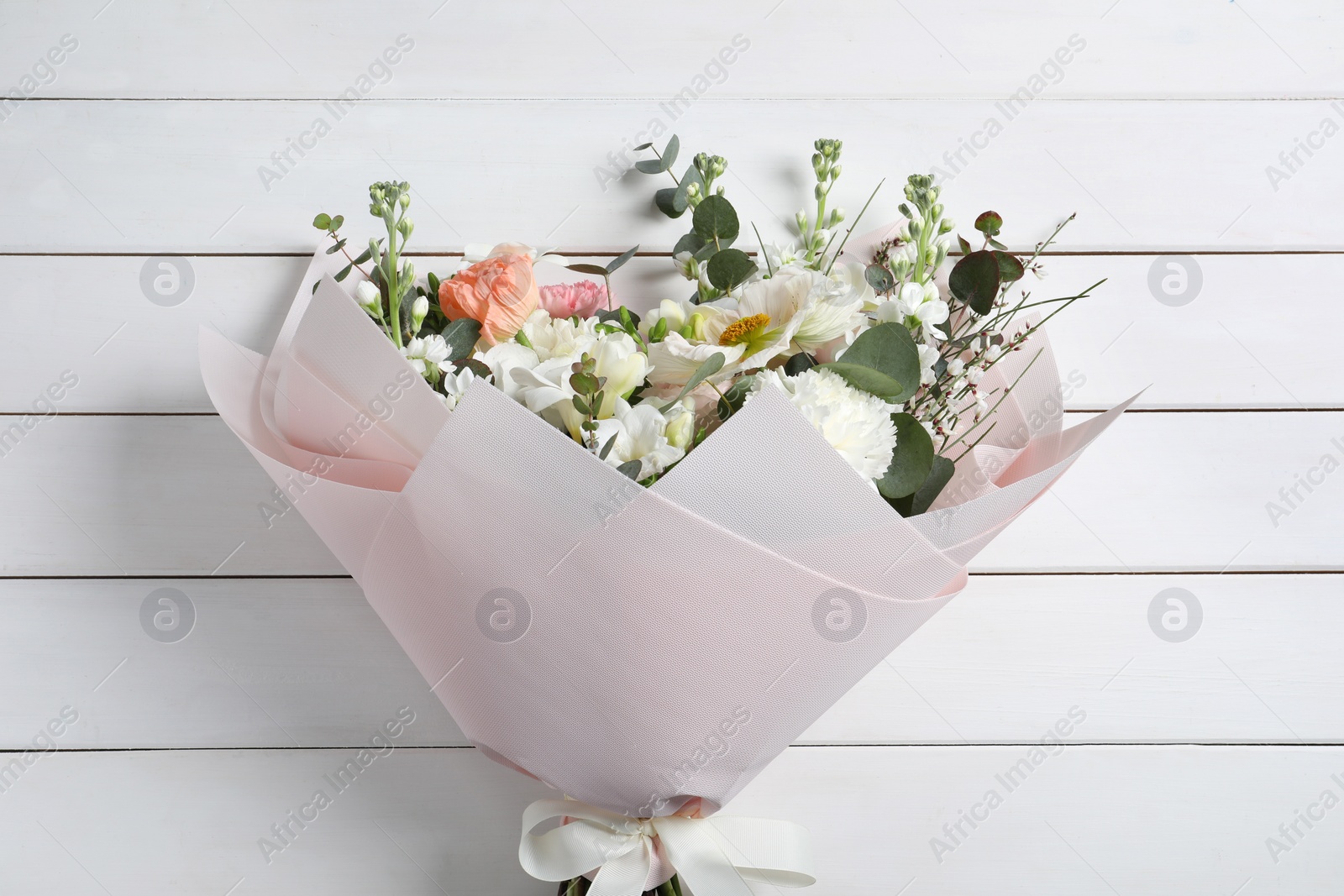 Photo of Bouquet of beautiful flowers on white wooden table