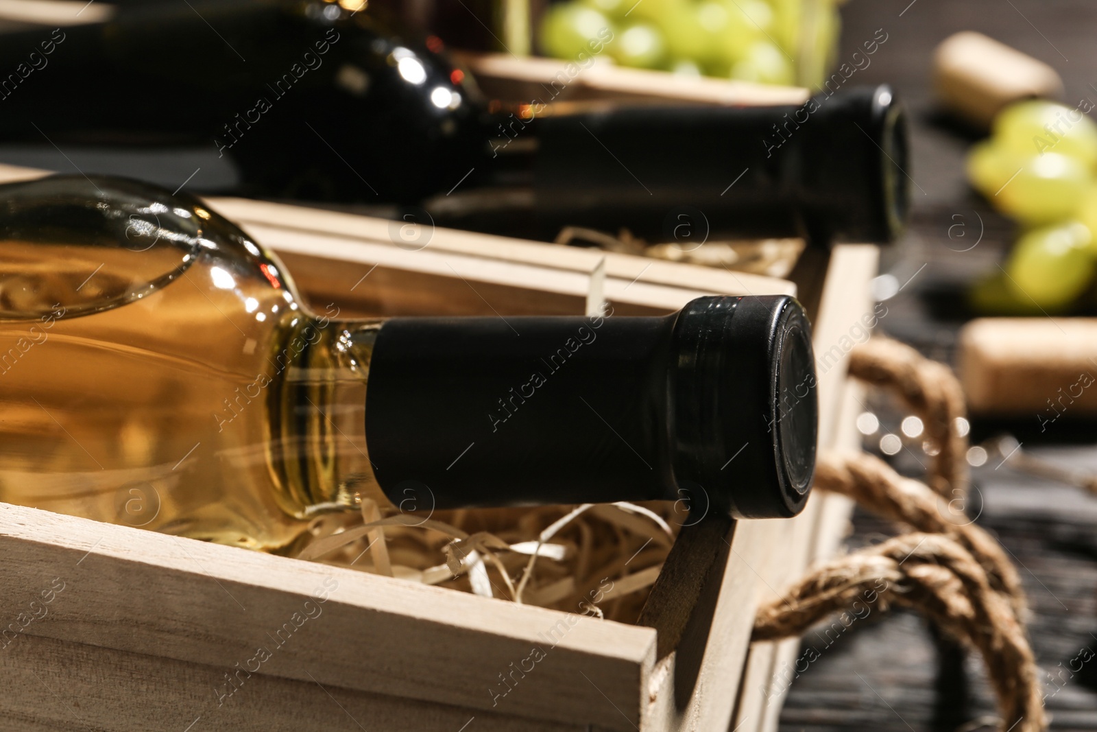 Photo of Wooden crates with bottles of wine on table, closeup
