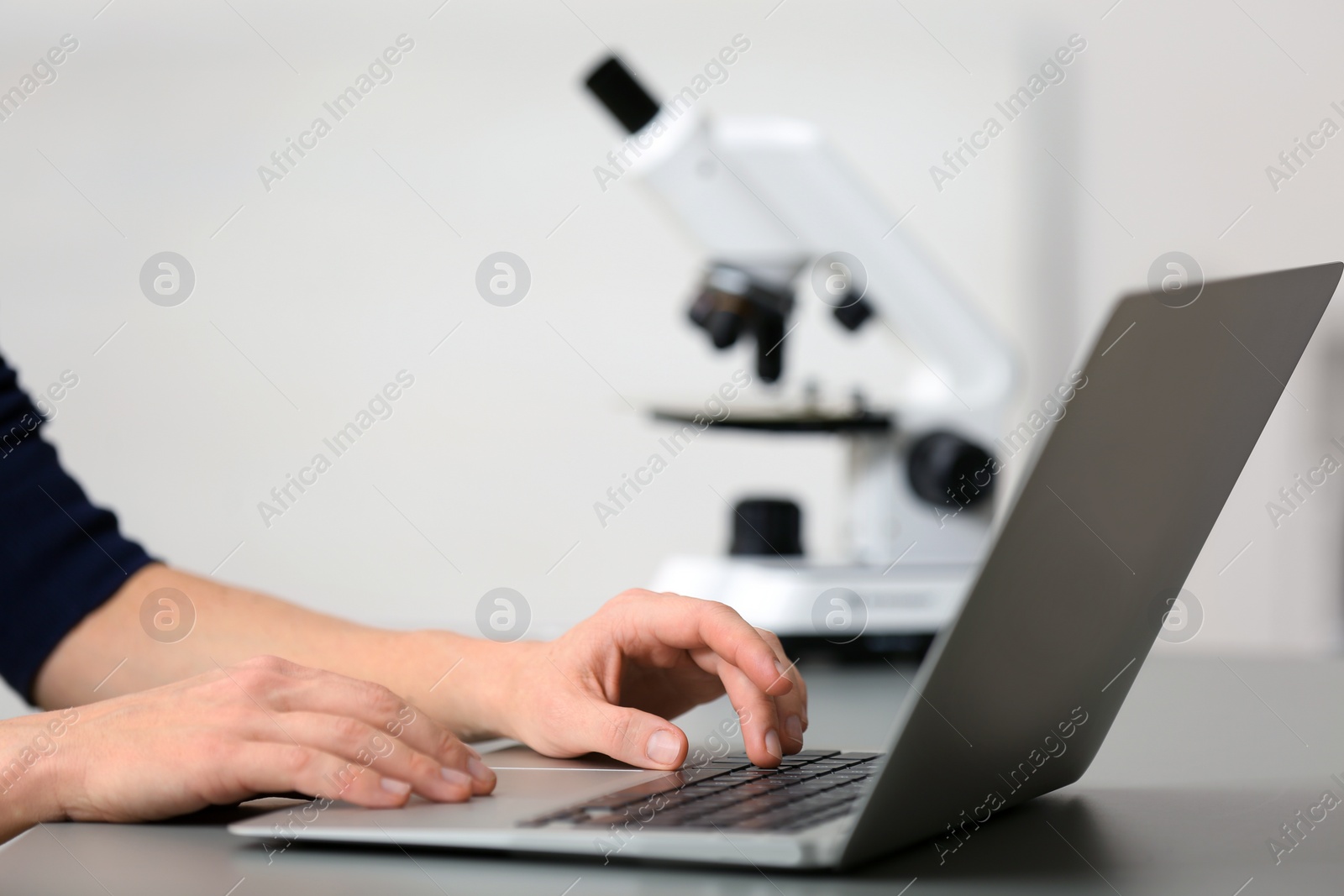 Photo of Female student working with laptop at table. Medical education