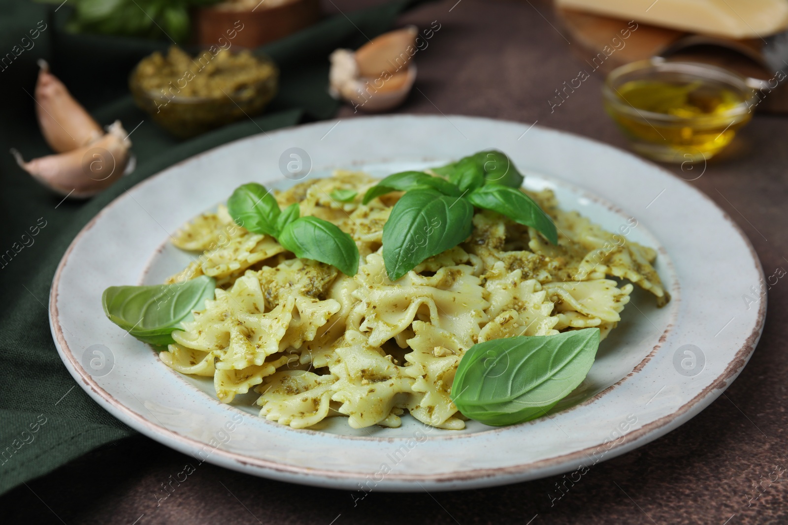 Photo of Delicious pasta with pesto sauce and basil on table, closeup