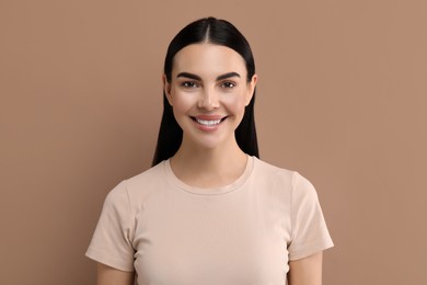 Photo of Beautiful woman with clean teeth smiling on beige background