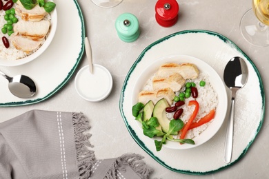 Photo of Boiled rice with vegetables and meat served on table, flat lay