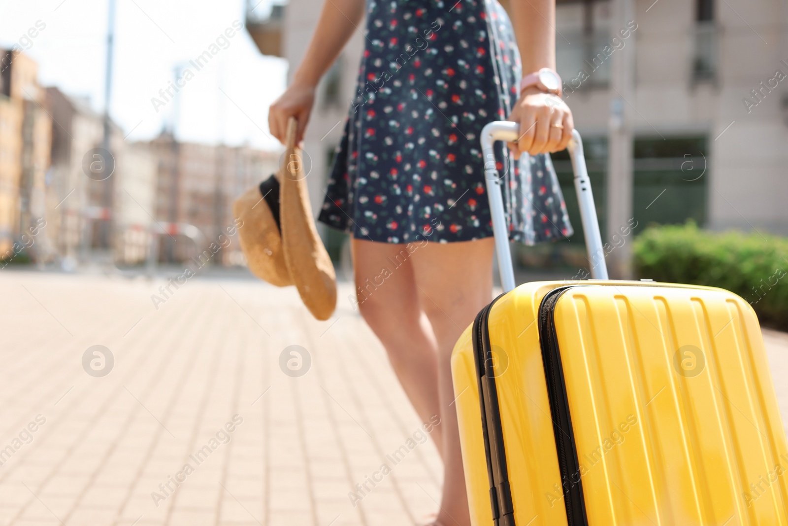 Photo of Young woman with yellow carry on suitcase outdoors