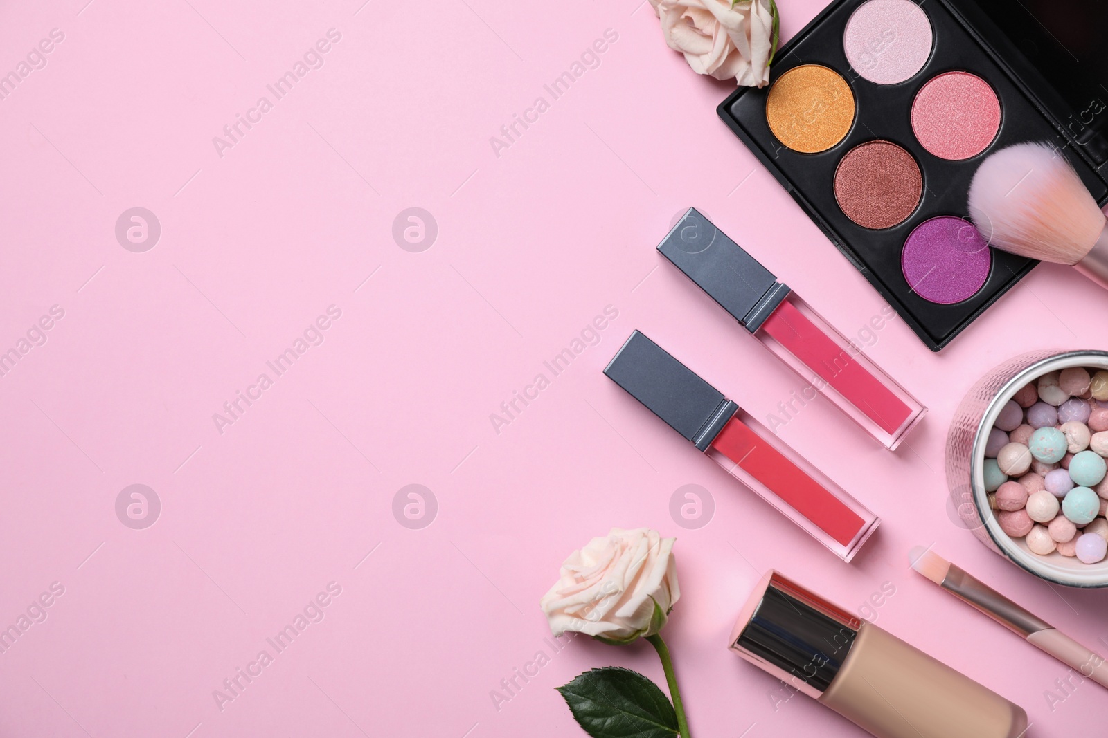 Photo of Flat lay composition with makeup products and roses on pink background, space for text