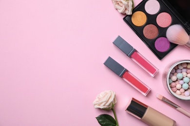 Photo of Flat lay composition with makeup products and roses on pink background, space for text